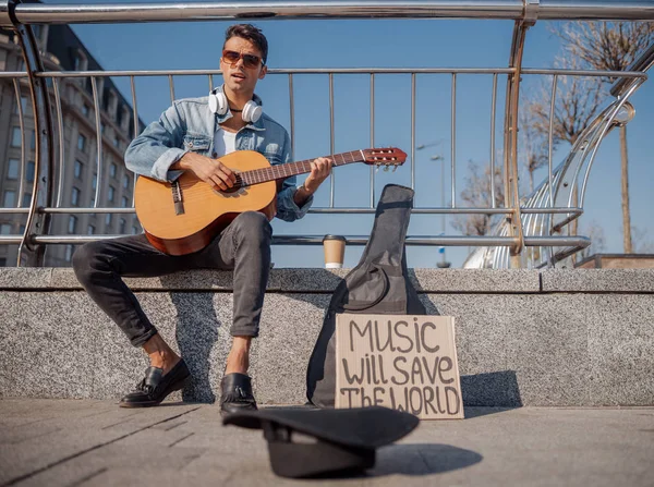 Jovem guitarrista sentado e tocando na rua — Fotografia de Stock