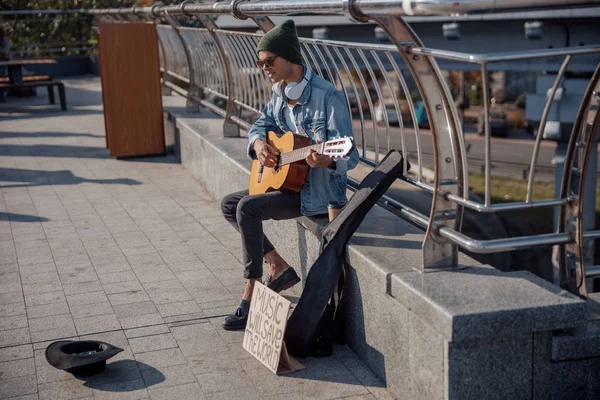 Stylischer Typ mit Brille, der in der Stadt Gitarre spielt — Stockfoto