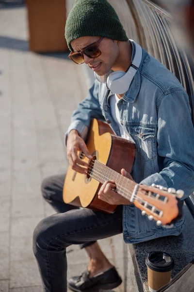 Guitarrista sorridente de chapéu tocando música na rua — Fotografia de Stock