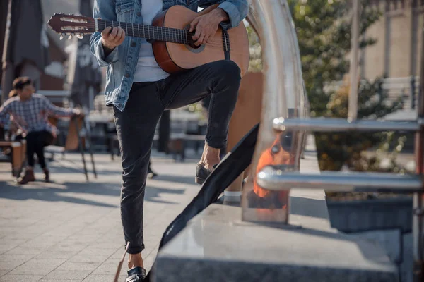 Jovem segurando guitarra e tocando na rua — Fotografia de Stock