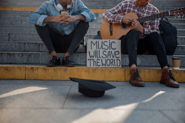 Dois caras sentados nos degraus com um cartaz ao lado deles — Fotografia de Stock