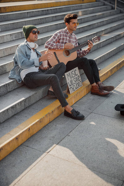 Guys sitting on the steps and looking in front of them
