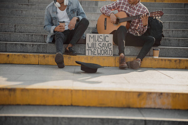 Cardboard plate with inscription near two guys