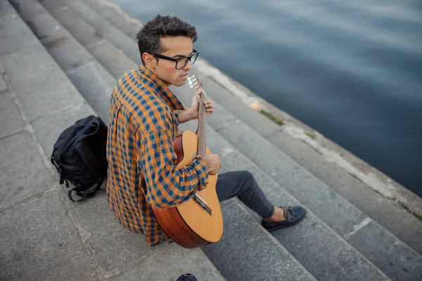 Cara elegante em óculos tocando guitarra ao ar livre — Fotografia de Stock