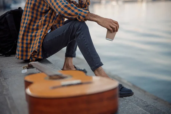 Guitarrista está sentado com café e guitarra — Fotografia de Stock