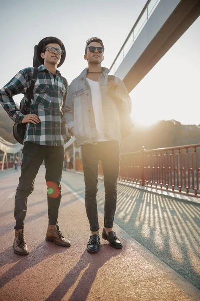 Zwei stylische Freunde stehen auf einer Brücke im Freien — Stockfoto