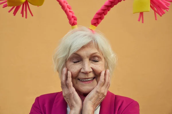 Χαρούμενη ηλικιωμένη γυναίκα με αστεία αξεσουάρ κεφαλής Στοκ φωτογραφία — Φωτογραφία Αρχείου
