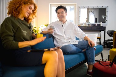 Ofisteki görüşme sırasında gülümseyen Asyalı genç adam.