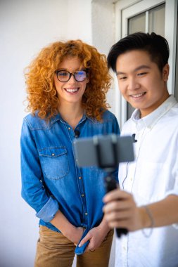Mutlu adam ve kadın video çekerken akıllı telefona bakıyorlar