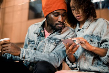 Açık havada akıllı telefondan yazı yazan çekici genç bayan.