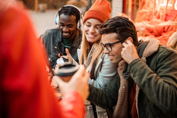 Smiling young guy listening to music with friends nearby — 스톡 사진