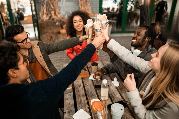 Happy přátelé toasting s šálky kávy venku — Stock fotografie