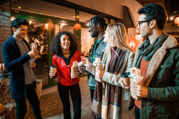 Heureux jeunes hommes et femmes debout avec du café dans la rue — Photo