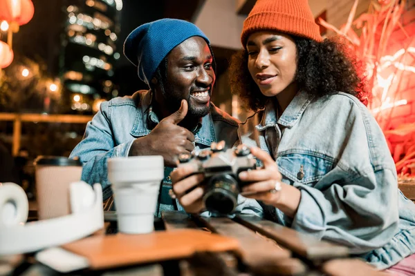 Joven afroamericano chico mirando bonita mujer en café al aire libre — Foto de Stock