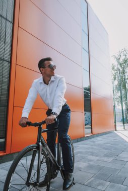 Bisiklet sürerken gülümseyen adam.