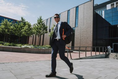 Sırt çantasıyla gezen neşeli yönetici.