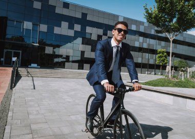 Neşeli çalışan bisiklet stoğunda ofisten ayrılıyor.