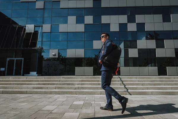 Empleado sonriente va a trabajar con la foto de stock mochila — Foto de Stock