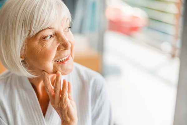 Alegre anciana mirando hacia otro lado y sonriendo — Foto de Stock