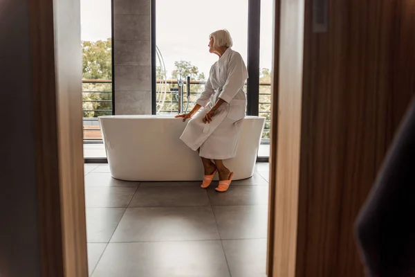 Mujer mayor sentada en el borde de la bañera —  Fotos de Stock