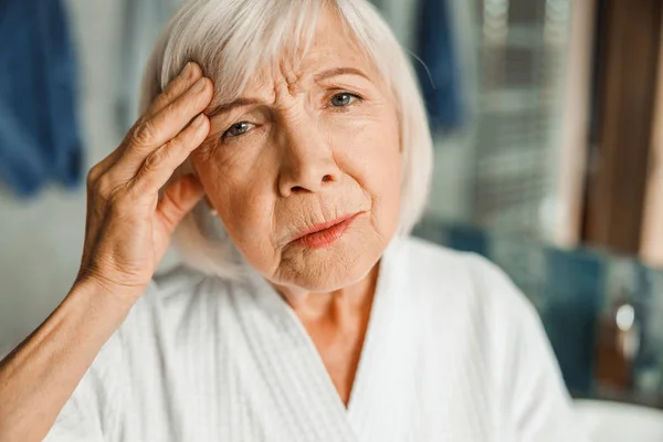 Molesto anciana tocando la frente y tener dolor de cabeza — Foto de Stock