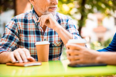 Masada oturan kıdemli bir adam bir fincan kahveyle