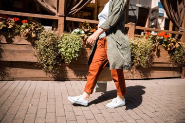 Spor ayakkabılı yaşlı bayan sokakta yürüyor.