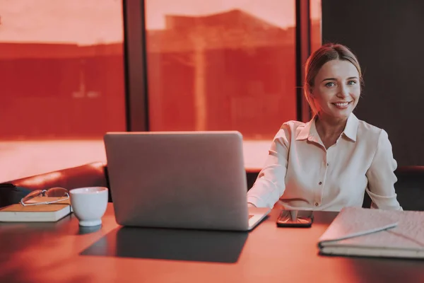 Fröhliche junge Frau arbeitet im Büro am Laptop — Stockfoto