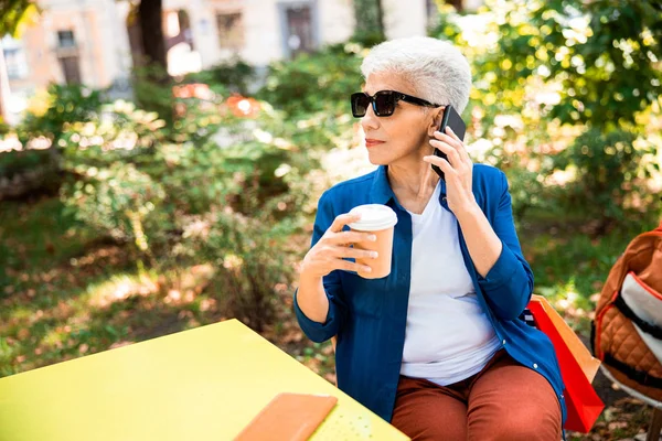 Elegante señora madura hablando por teléfono celular en la calle — Foto de Stock