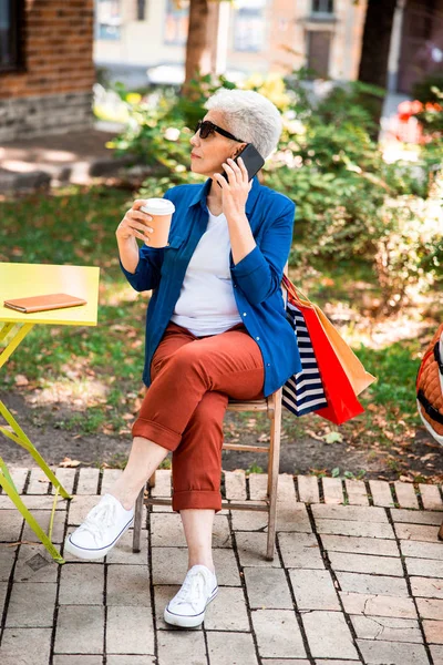 Stylish mature lady talking on cellphone outdoors — Stock Photo, Image
