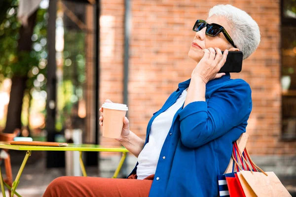 Señora mayor teniendo conversación telefónica en la calle — Foto de Stock