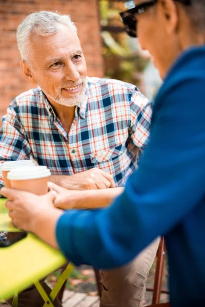 Hombre mayor alegre hablando con la señora en la cafetería al aire libre — Foto de Stock