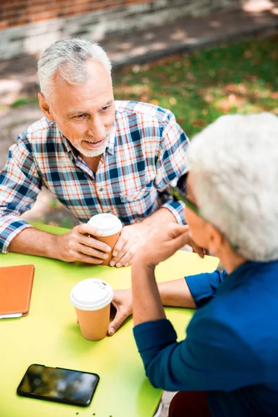 Senior pije kawę i rozmawia z damą w kawiarni na świeżym powietrzu — Zdjęcie stockowe