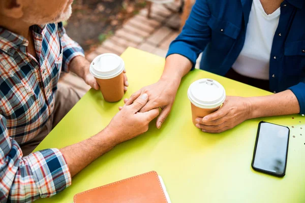 高级情侣牵着手在露天咖啡馆 — 图库照片