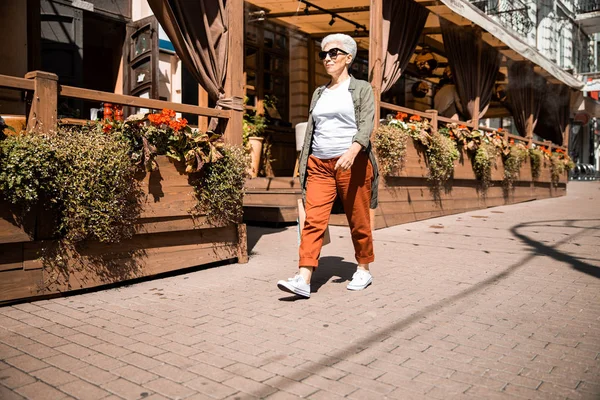 Femme âgée élégante marchant dans la rue — Photo