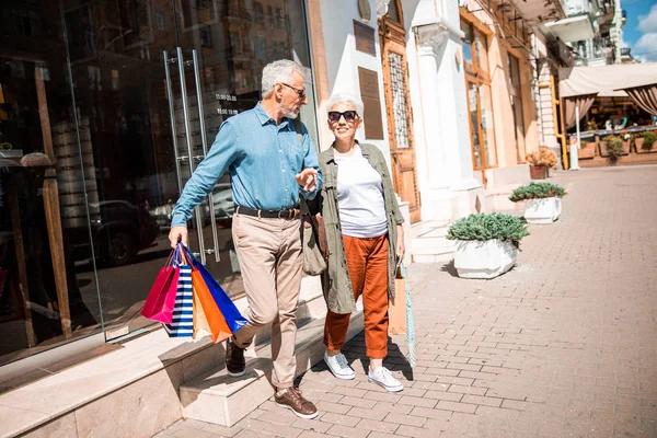 Hermosa pareja de ancianos saliendo de la tienda — Foto de Stock
