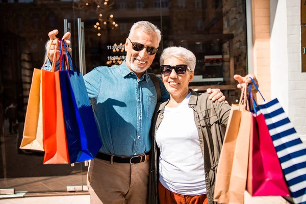 Hombre mayor abrazando a su esposa y sonriendo — Foto de Stock