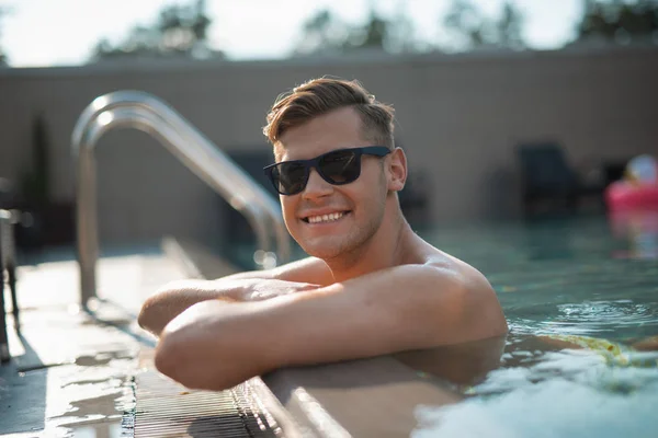 Joven alegre relajándose en la piscina — Foto de Stock