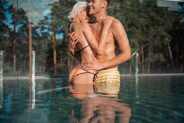 Belo jovem casal apaixonado abraçando na piscina — Fotografia de Stock