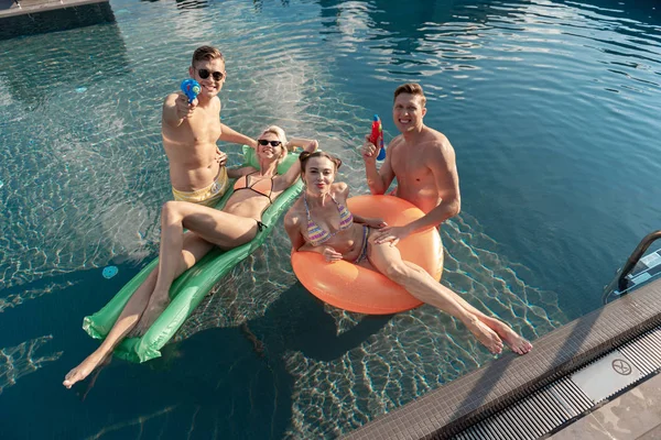 水泳プールでリラックスしている陽気な若者たち — ストック写真