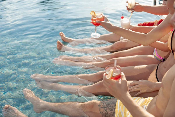 Jóvenes con bebidas relajantes en la piscina — Foto de Stock