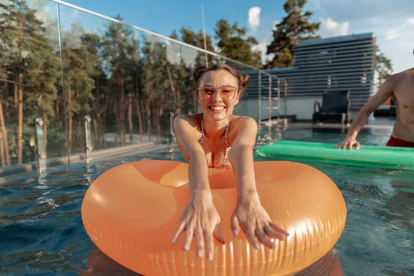 Mulher nova bonita nadando com anel inflável — Fotografia de Stock