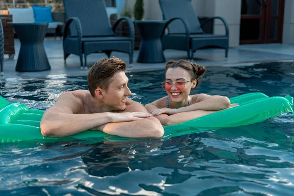 Happy young couple swimming on inflatable matrass — Stock Photo, Image