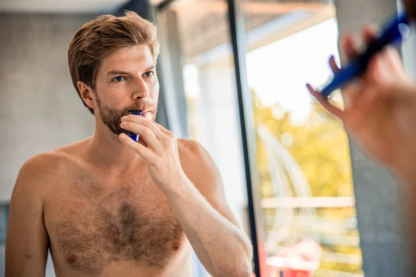 Guapo joven afeitándose con afeitadora eléctrica — Foto de Stock