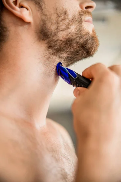 Jongeman scheren met elektrisch scheermes in de ochtend — Stockfoto