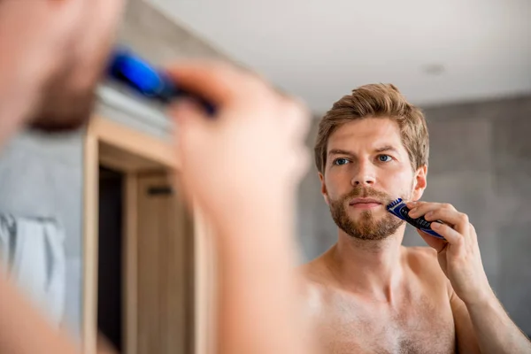 Knappe jongeman trimmen en rand baard — Stockfoto