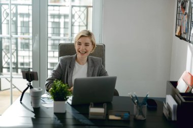 Ofiste dizüstü bilgisayarla çalışan mutlu bir bayan.