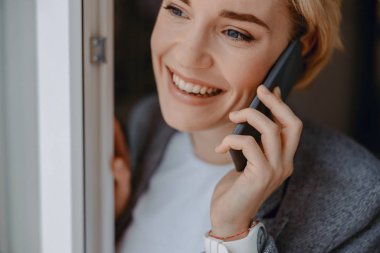 Mutlu genç bayan cep telefonu kullanıyor.