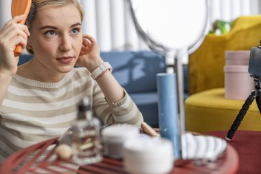 Evde tarak kullanan güzel genç bir bayan.