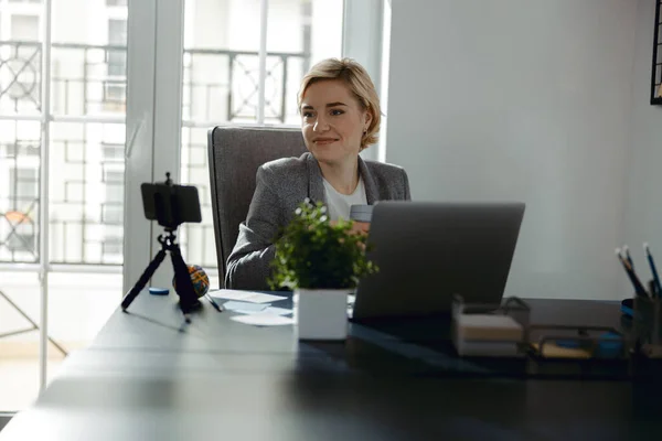 Щаслива красива леді сидить у своєму офісі — стокове фото